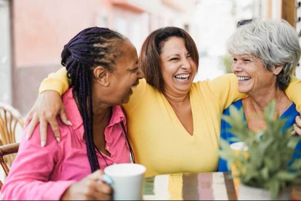 3 senior women chatting cheerfully in a coffee shop