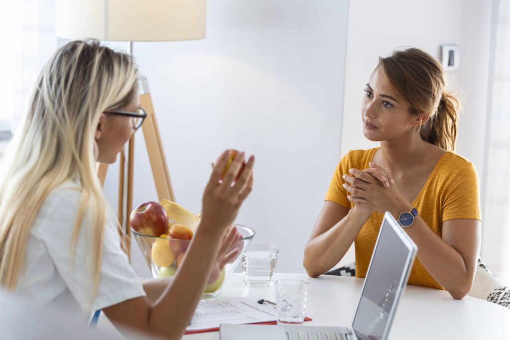 A woman client having a supportive conversation with her nutritionist about health and Cycle Syncing Diet