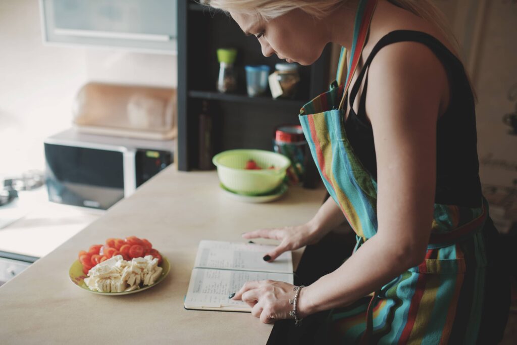 a woman is taking notes of a diet to control her blood sugar
