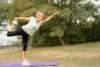 A woman (mid-50s to 60s) in comfortable, stylish activewear, perhaps doing a gentle stretch, a yoga pose