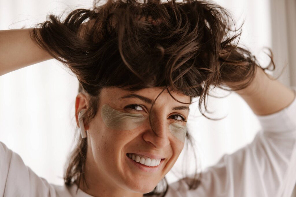 Close-up of woman smiling with new baby hairs along her hairline, showing progress in hair regrowth after hormone balance