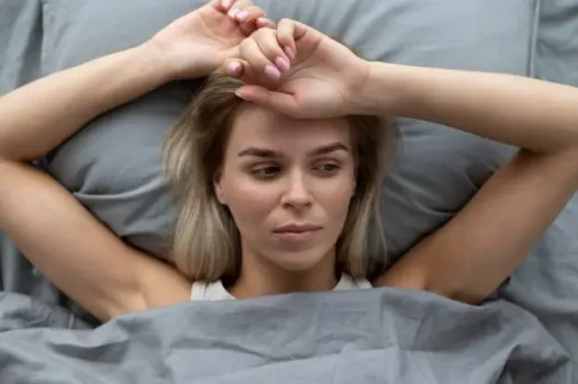 Midlife woman in bed suffering from Hormonal Insomnia
