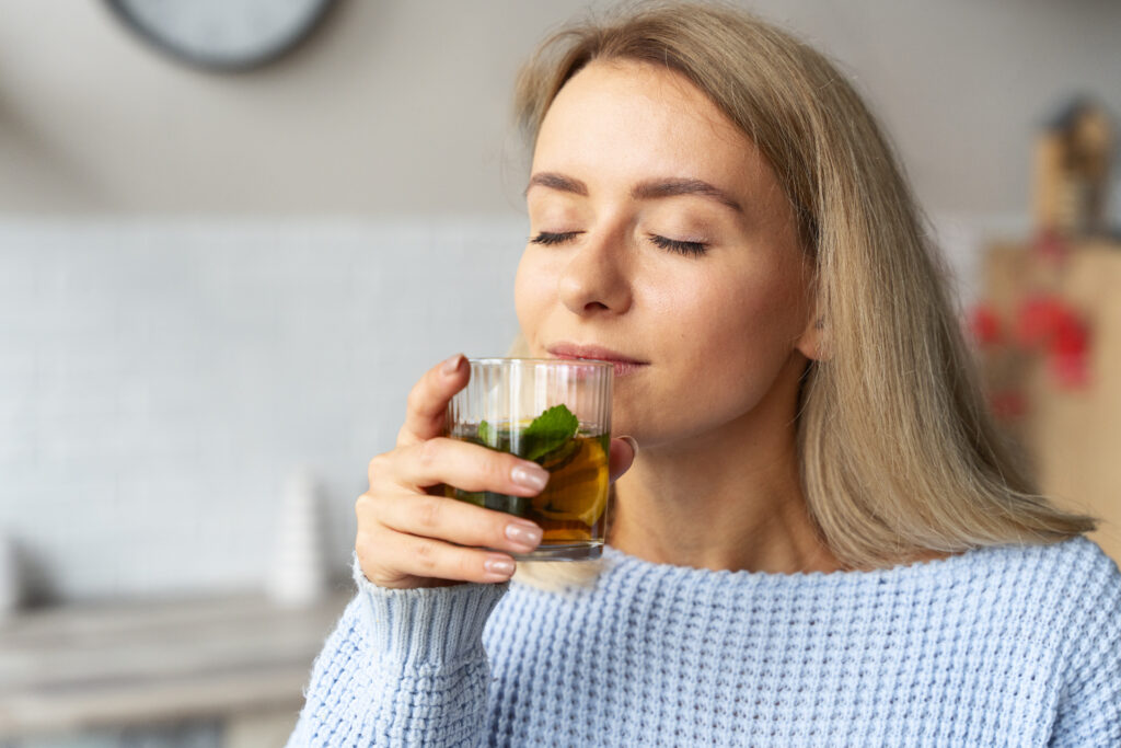 a relaxed woman drinking her spearmint tea which is one of natural remedies for hormonal skin problems