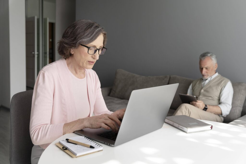A senior woman with the right body posture in front of her laptop to preserve herself from back pain menopause